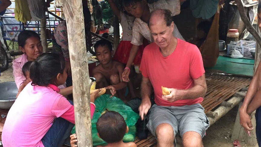 James Ricketson talking to some children in Cambodia.