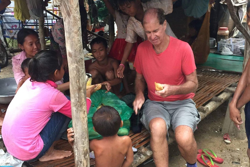 James Ricketson talking to some children in Cambodia.