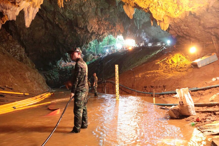 Thai rescue teams arrange water pumping system at the entrance to the flooded cave
