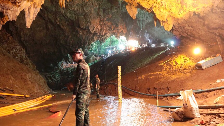 Thai rescue teams arrange water pumping system at the entrance to the flooded cave