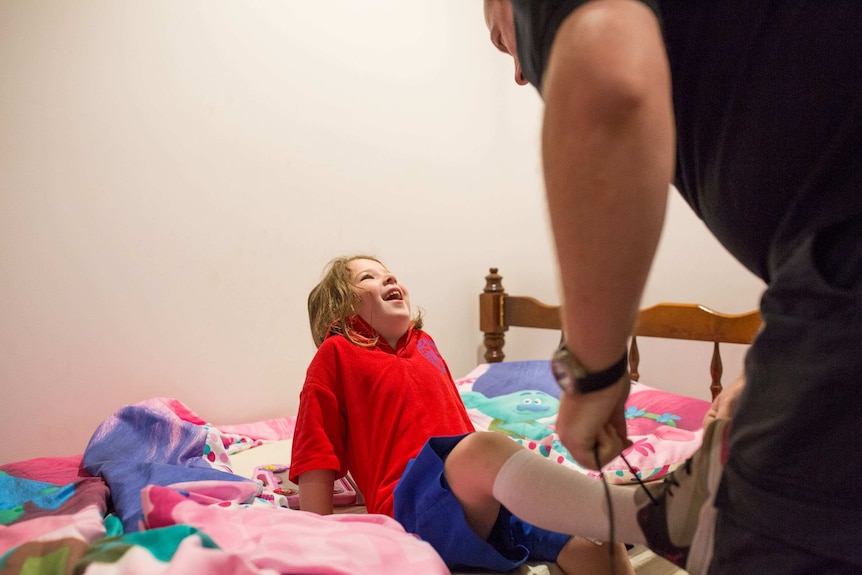 Chloe McMurtrie's dad Rodney helping her get dressed.