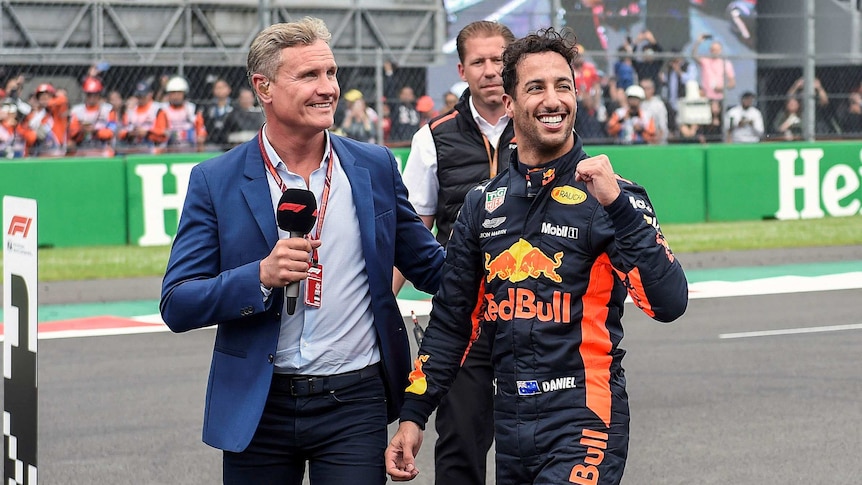 Daniel Ricciardo pumps his fist while walking on the Mexico GP track with interviewer David Coulthard.