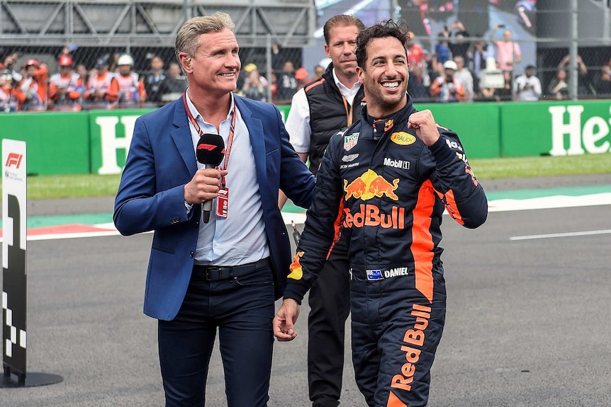 Daniel Ricciardo pumps his fist while walking on the Mexico GP track with interviewer David Coulthard.