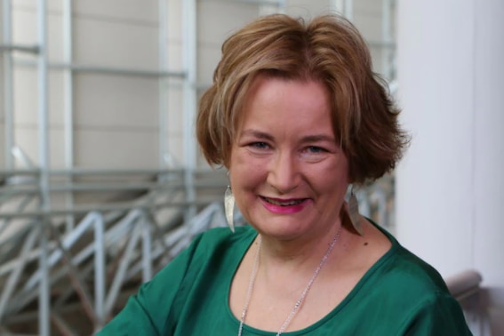 Jackie French wearing green smiles at the camera.