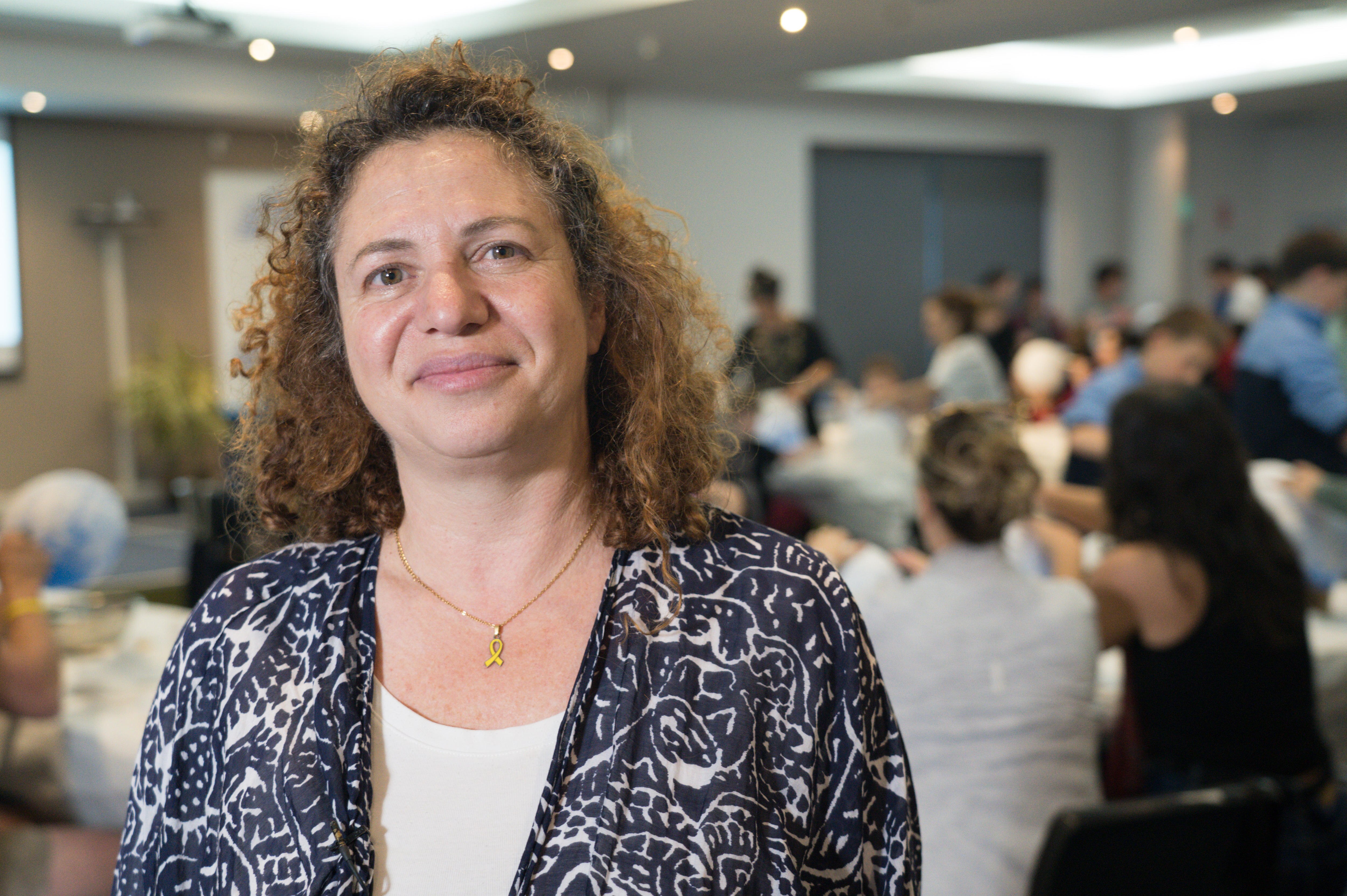 A woman in a room of people making paper mache lanterns