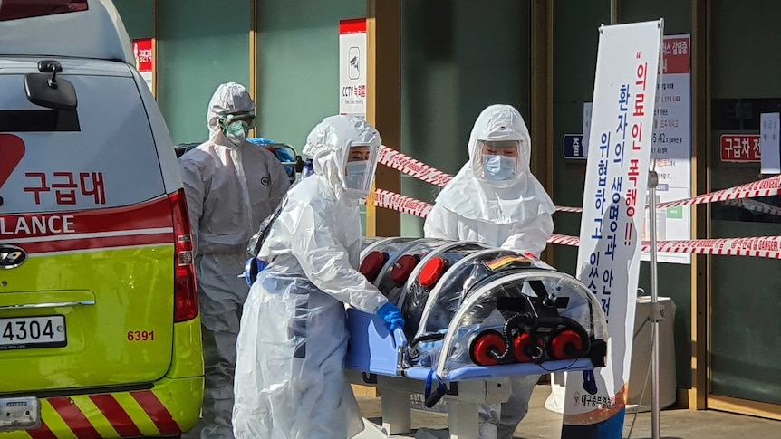 Medical workers wearing protective gear move a patient suspected of contracting the new coronavirus.