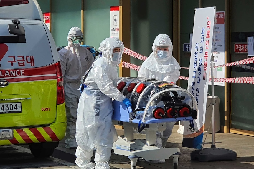 Medical workers wearing protective gear move a patient suspected of contracting the new coronavirus.