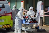 Medical workers wearing protective gear move a patient suspected of contracting the new coronavirus.