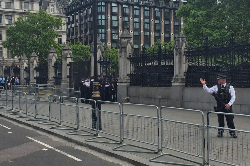 Police wave traffic through outside Britain's Houses of Parliament.