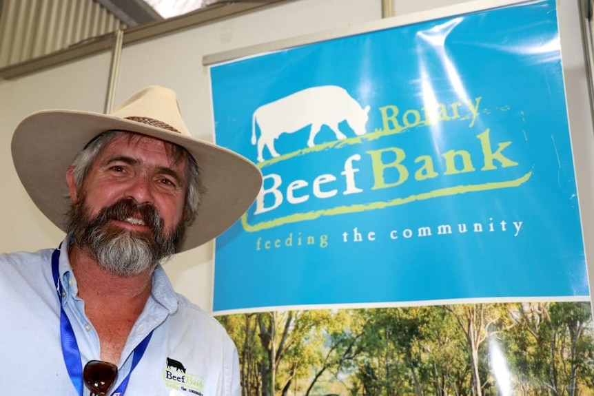Andrew Rogers wearing a hat standing front of a blue Beefbank sign