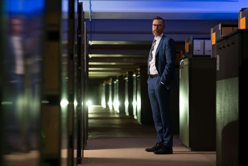 Professor standing in a dark storage unit.