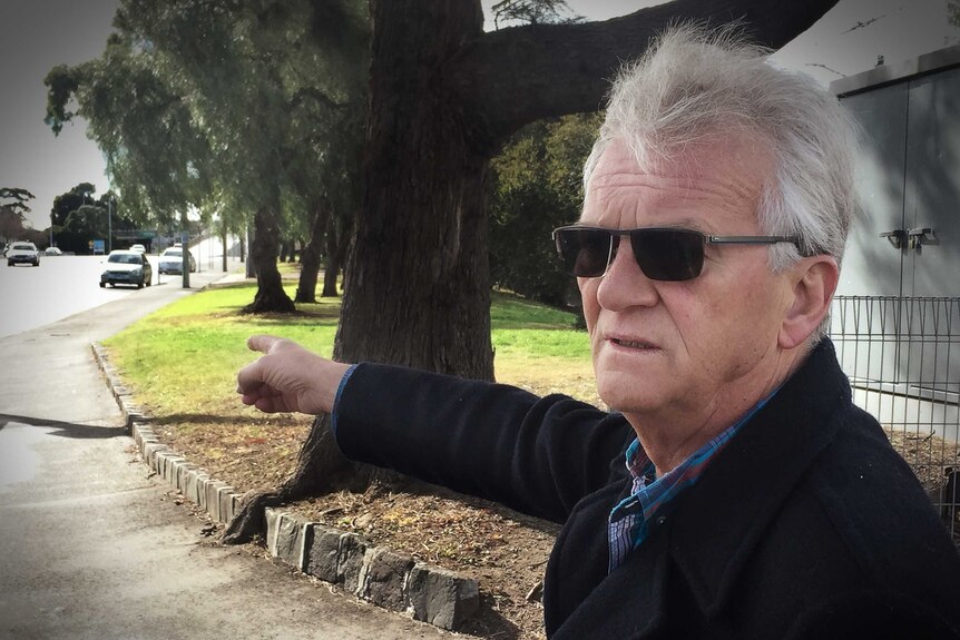 Former detective Peter Butts points to the road on Hoddle Street.