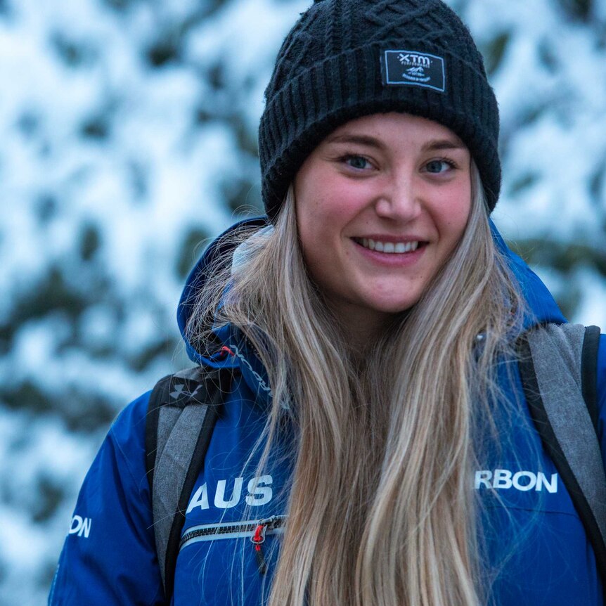 Sarah Blizzard stands in front of a snowy backdrop