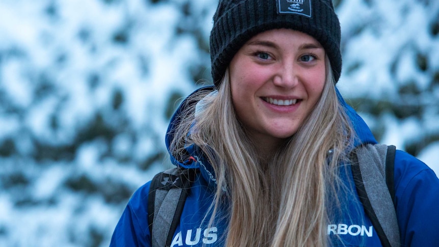 Sarah Blizzard stands in front of a snowy backdrop