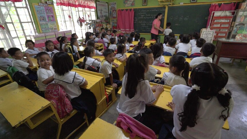 Denielle Josua Pagco sits with his classmates in a school classroom