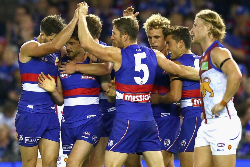 Western Bulldogs' Tom Liberatore is congratulated by team-mates for his goal against Brisbane.