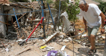 Israeli man inspects damage after house his by rocket fire