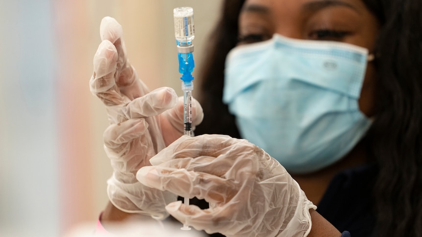 A health worker loads syringes with the vaccine on the first day of the Johnson & Johnson vaccine being made available.