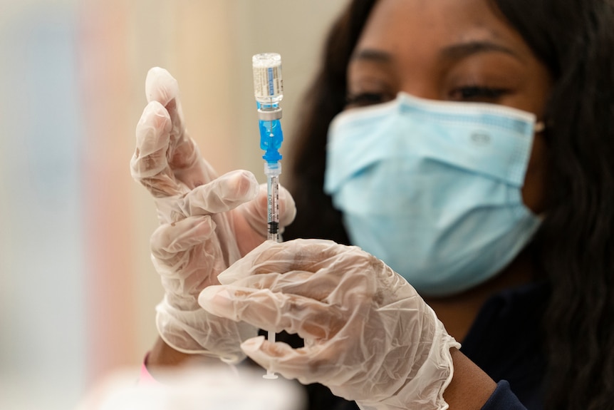 A health worker loads syringes with the vaccine on the first day of the Johnson & Johnson vaccine being made available.