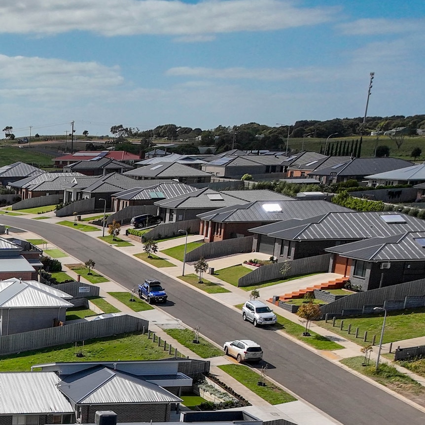 A line of new houses with identically coloured black roofs.