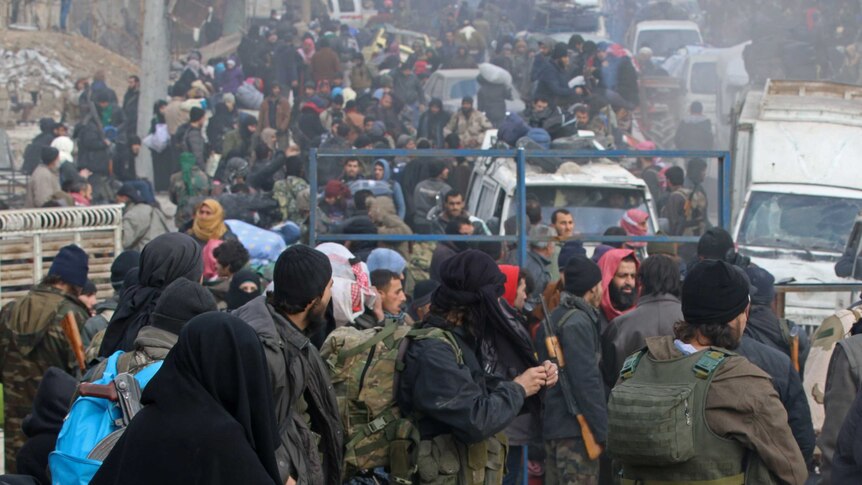 Hundreds of Syrian rebel fighters and civilians gathering for evacuations.