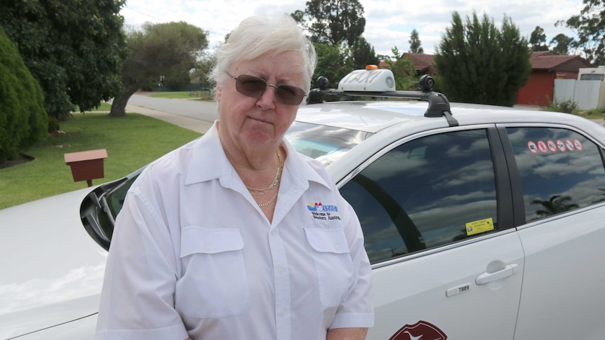 Pat Hart stands in front of her taxi.