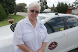 Pat Hart stands in front of her taxi.