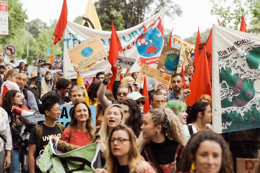 A large crowd of Extinction Rebellion protesters waving banners.