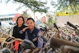 President of Bikes for Humanity Melbourne Andy Gild with volunteer Jamie Chan surrounded by hundreds of bikes.