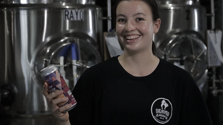 Nayana Patmore holding a beer in a brewery.