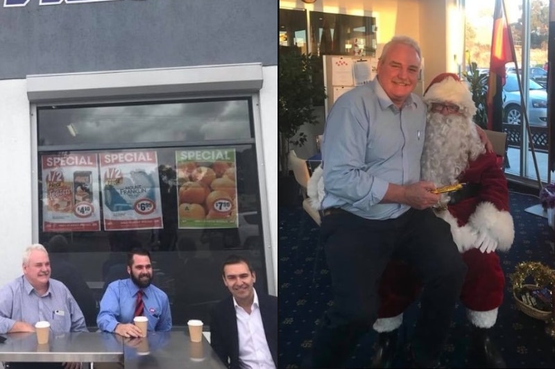 Men sitting in front of a supermarket with takeaway coffees and a man sitting on Father Christmas's lap