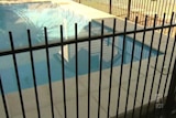 Fence surrounds a backyard pool