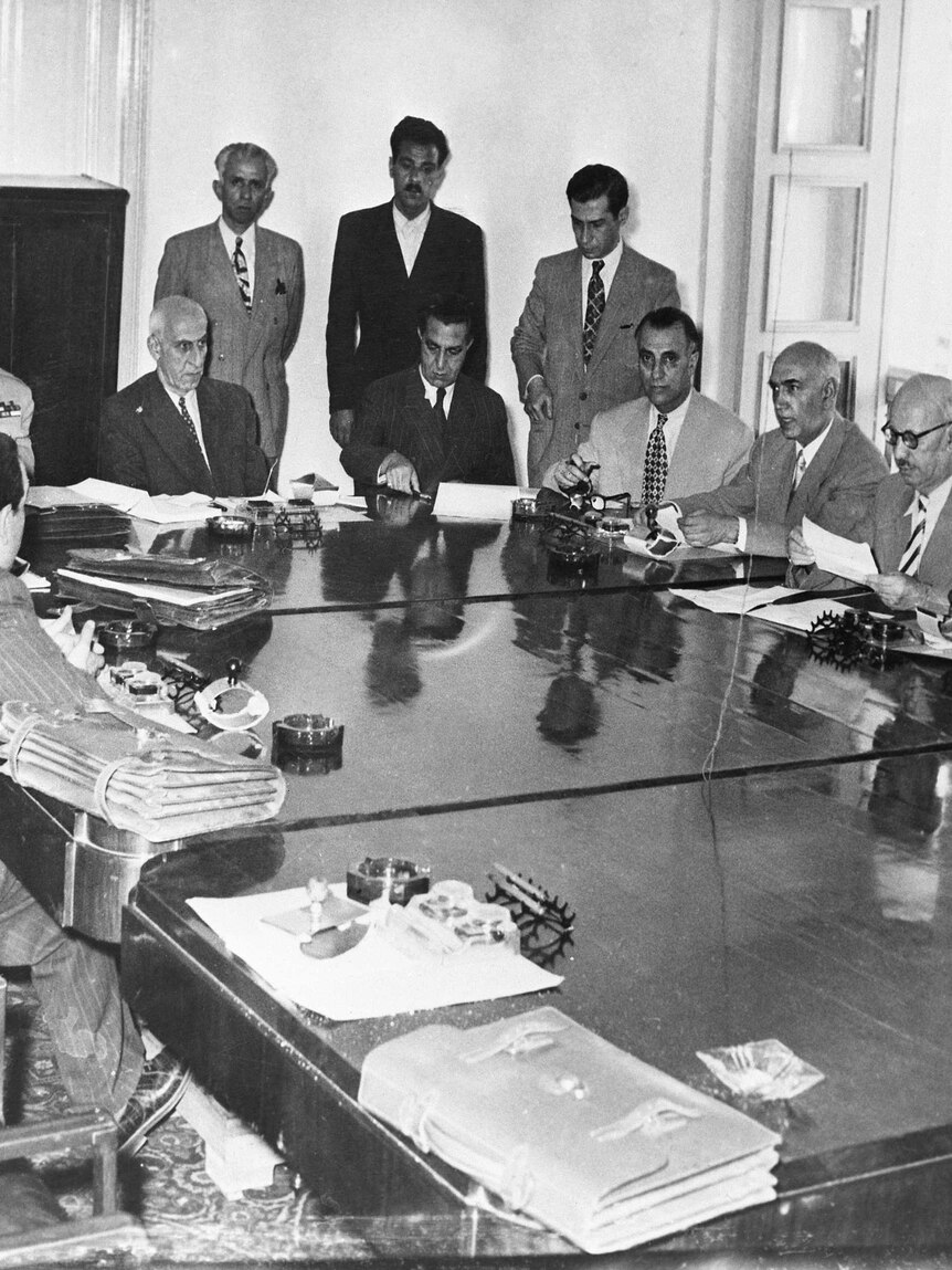 Black and white portrait of Mohammad Mosaddegh at cabinet meeting.