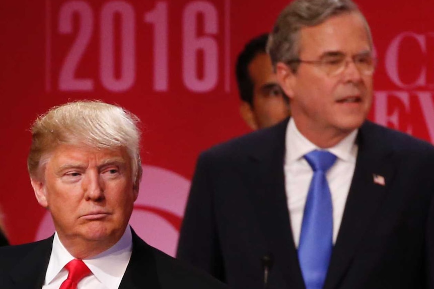 Jeb Bush stands on stage behind Donald Trump at the conclusion of the Republican US presidential candidate