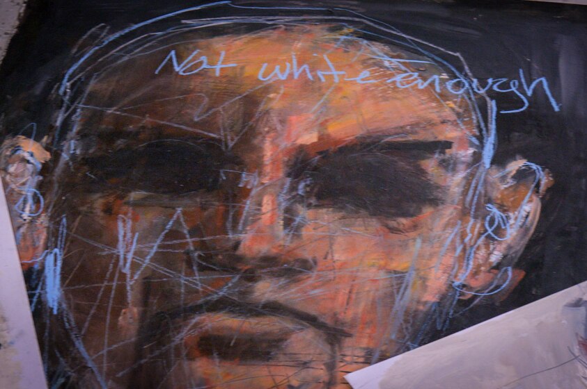 A painting of an Indigenous man's face, with not white enough written across his forehead.