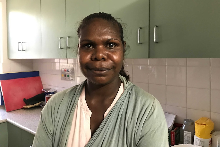 A woman stands in a kitchen.