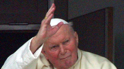 Pope John Paul II waves to the assembled crowd from his hospital room (file photo).
