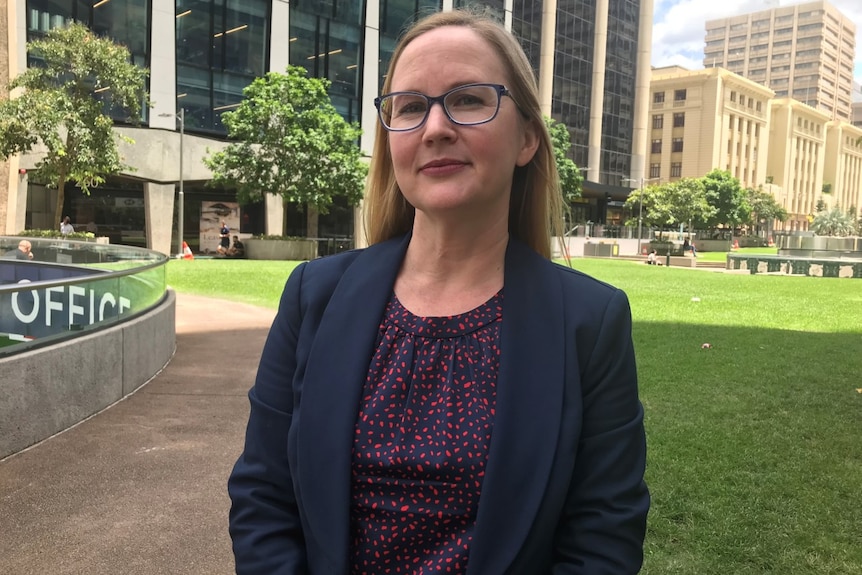 Jen Williams smiles in a suit.