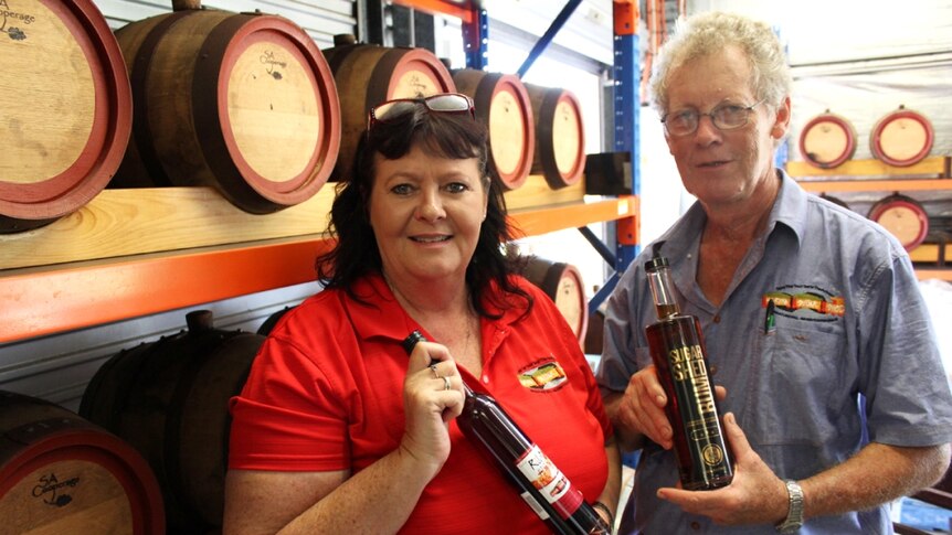 Sarina Sugar Shed's Glenys Mansfield and Phillip Taylor holding bottles of their award-winning rum