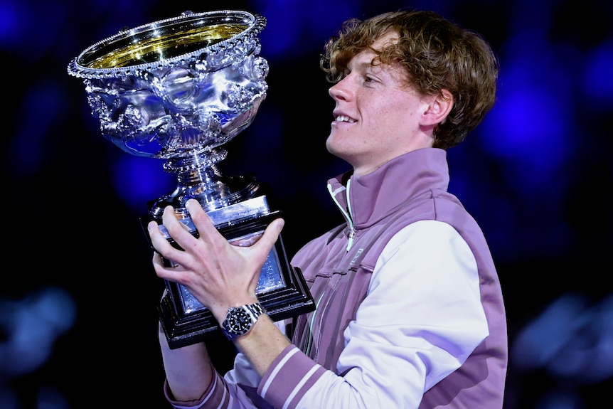 Jannik Sinner holds the Australian Open trophy after winning the 2024 men's final.