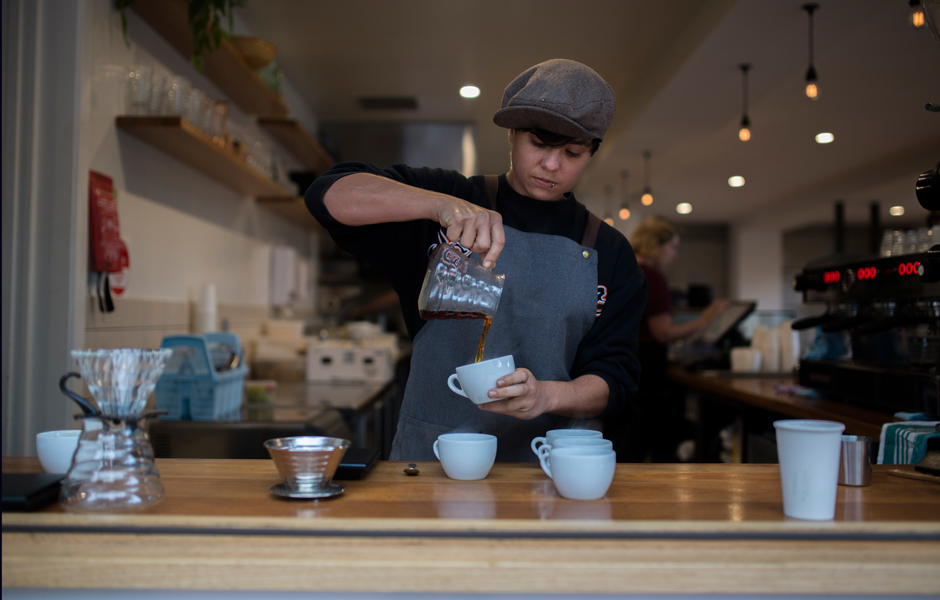 Barista Emma Bertoldi pours drip coffee at cafe, Rudimentary