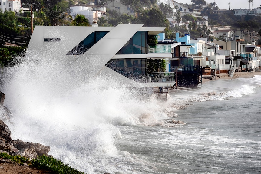 Le onde si infrangono su una casa lungo la costa californiana a Malibu Beach.