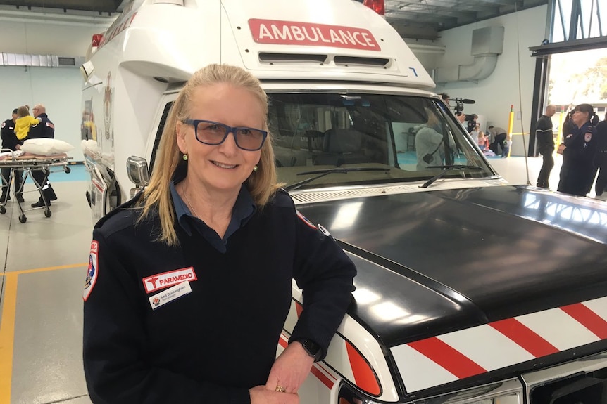 Mel Buckingham stands in front of an ambulance.