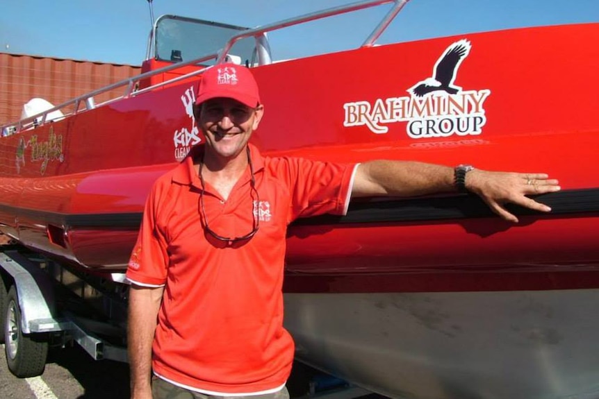 A man standing next to a boat.