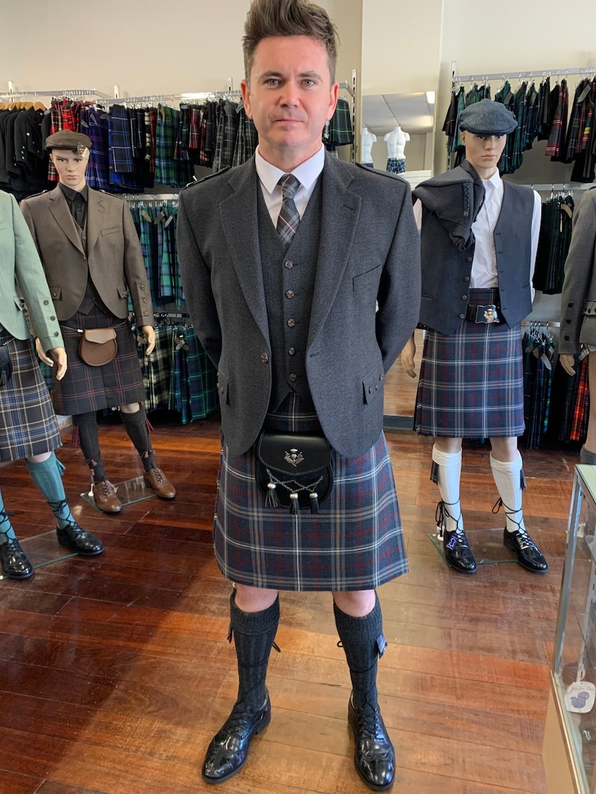 A man wearing a kilt as part of a traditional Scottish outfit.