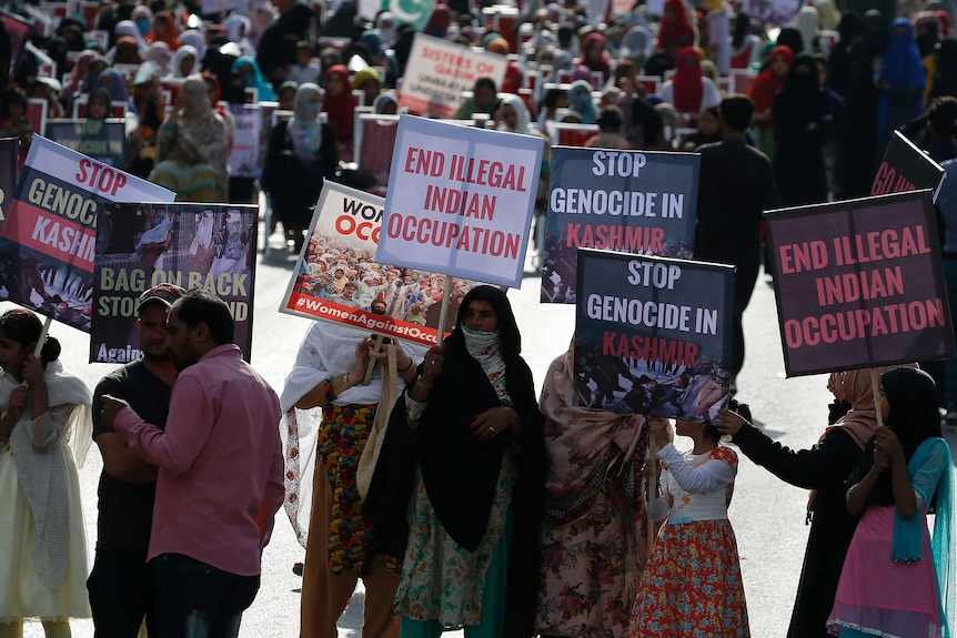 Hundreds of women at a rally hold signs demanding an end to Indian occupation of Kashmir