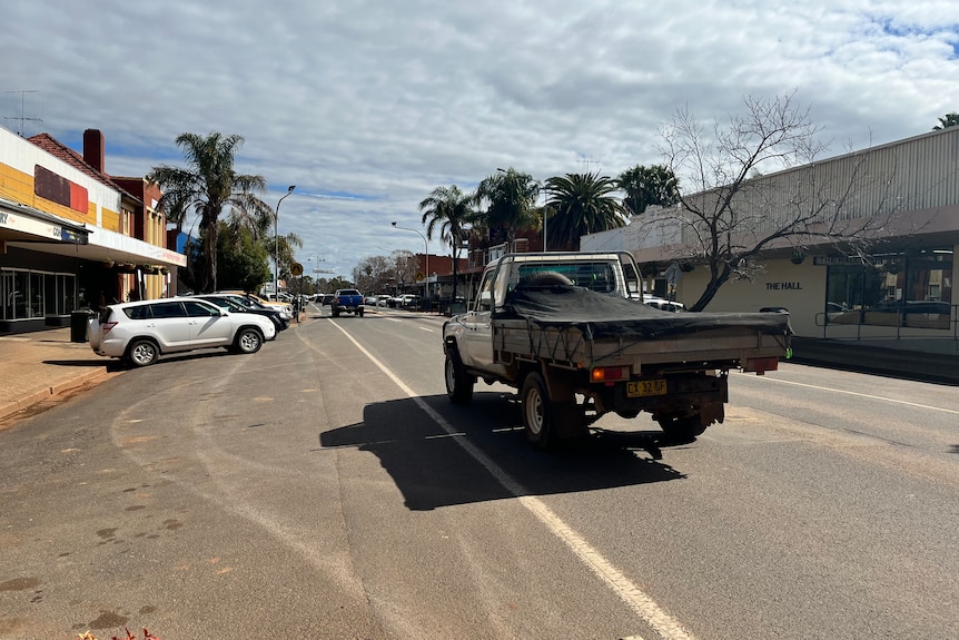 A ute drives down the main drag of a country town.