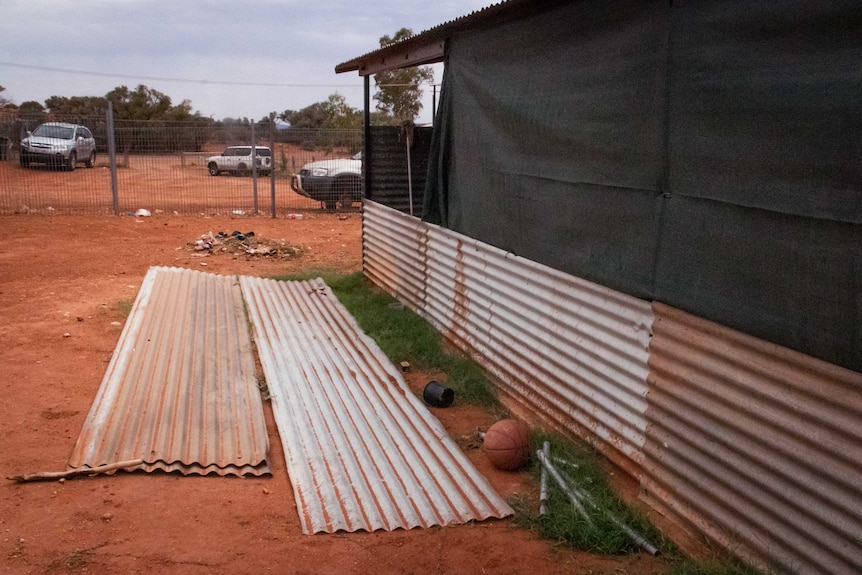 A dwelling with corrugated iron and mesh walls.