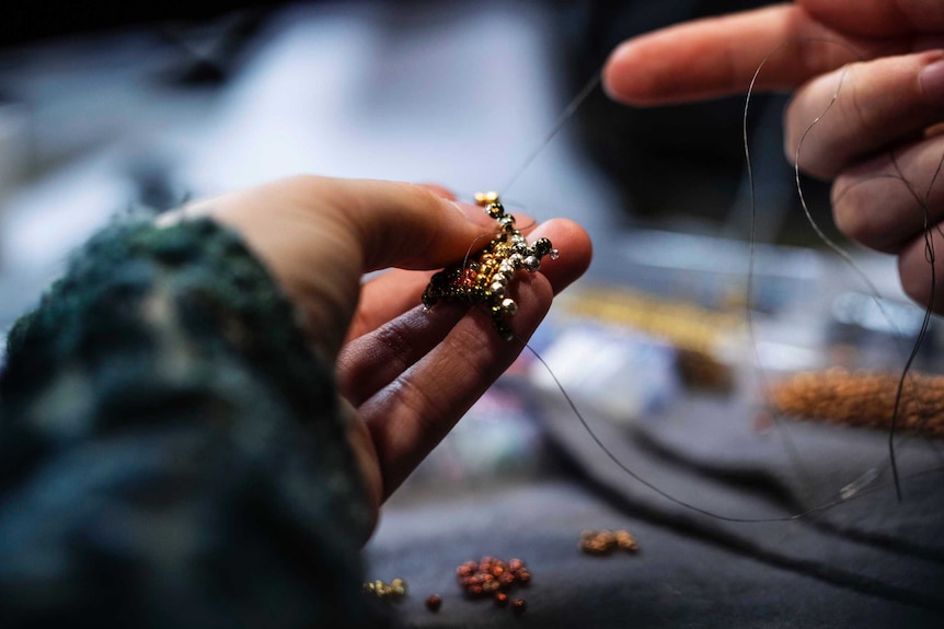 Asha Martin's hands work on a beading project.