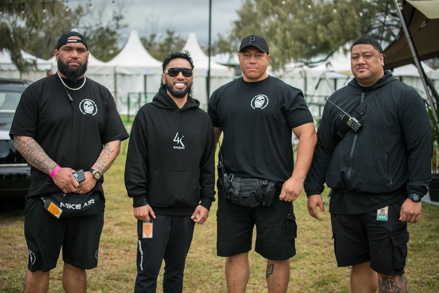 Four body guards standing next to each other.